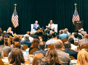 robin on stage with dr nido qubein, speaking during Influence 2022 conference