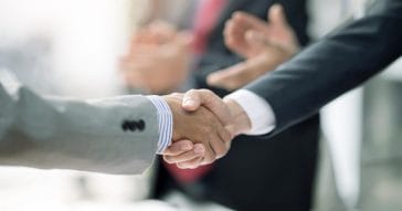 Two Businessman handshake for teamwork of business merger and acquisition at office.