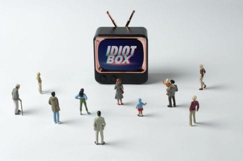 People figurines watching "Idiot Box" on TV. Post-truth concept